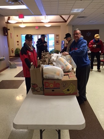 Distributing food baskets for the needy at Christmas, 2016